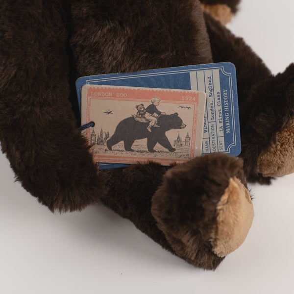 Wonderlings Winnipeg black bear plush toy beside its story postcard.